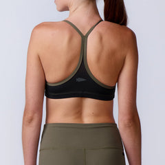 Woman wearing GORUCK olive green sports bra and leggings, back view, showcasing rucking gear