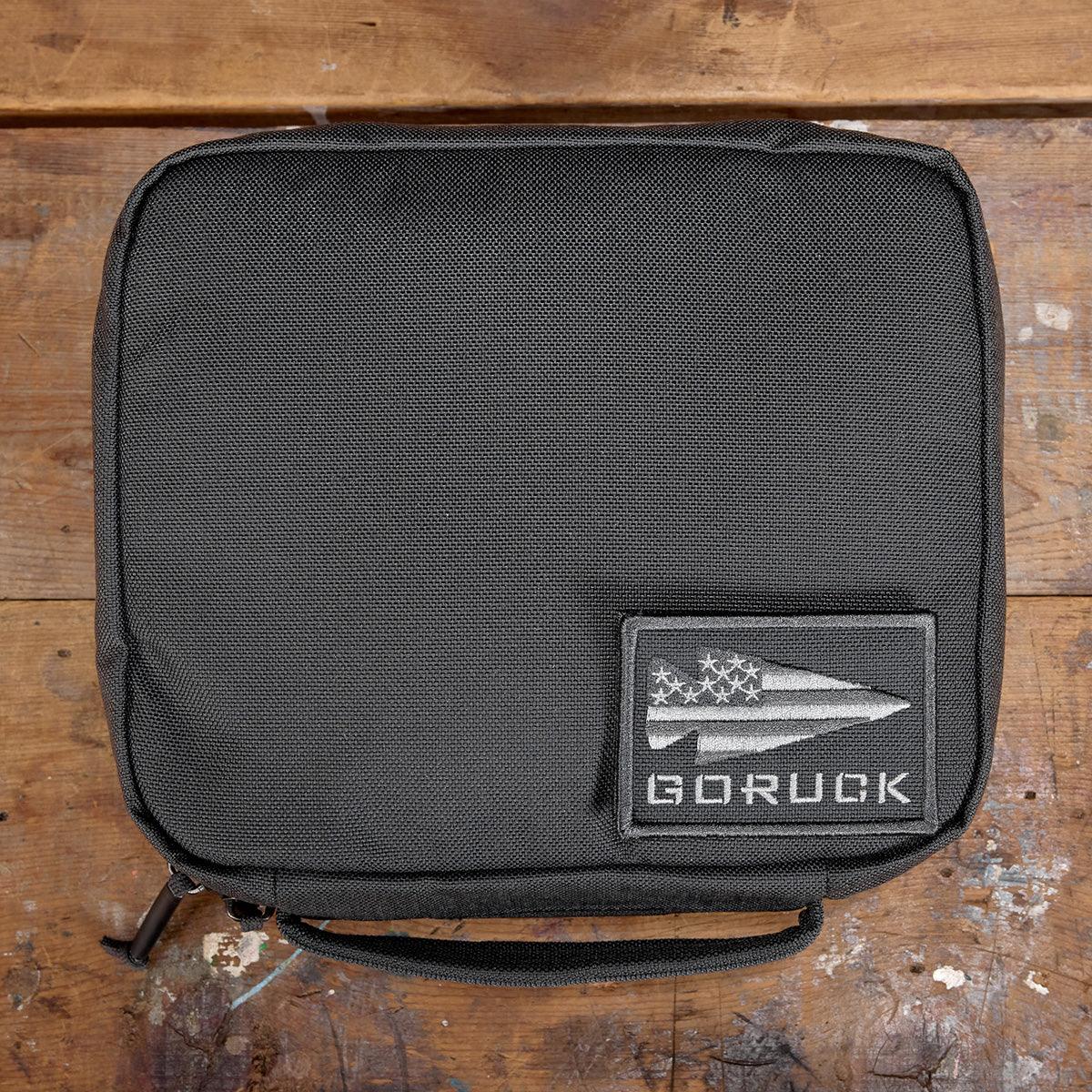 GORUCK padded field pocket in Armor Grey, displayed on wooden surface with GORUCK logo patch