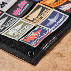 GORUCK patch board displaying various colorful rucking gear patches on a black panel