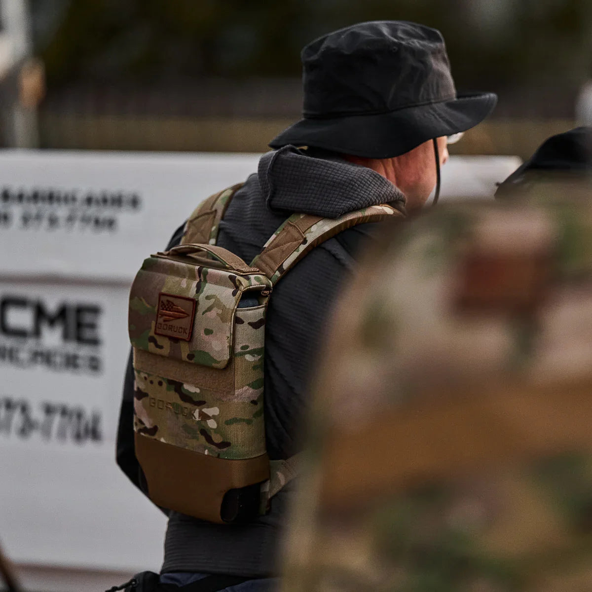 Person wearing a GORUCK multicam ruck plate carrier outdoors, rugged tactical gear.