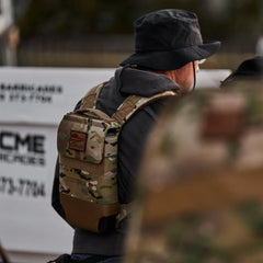 Person wearing a GORUCK multicam ruck plate carrier outdoors, rugged tactical gear.