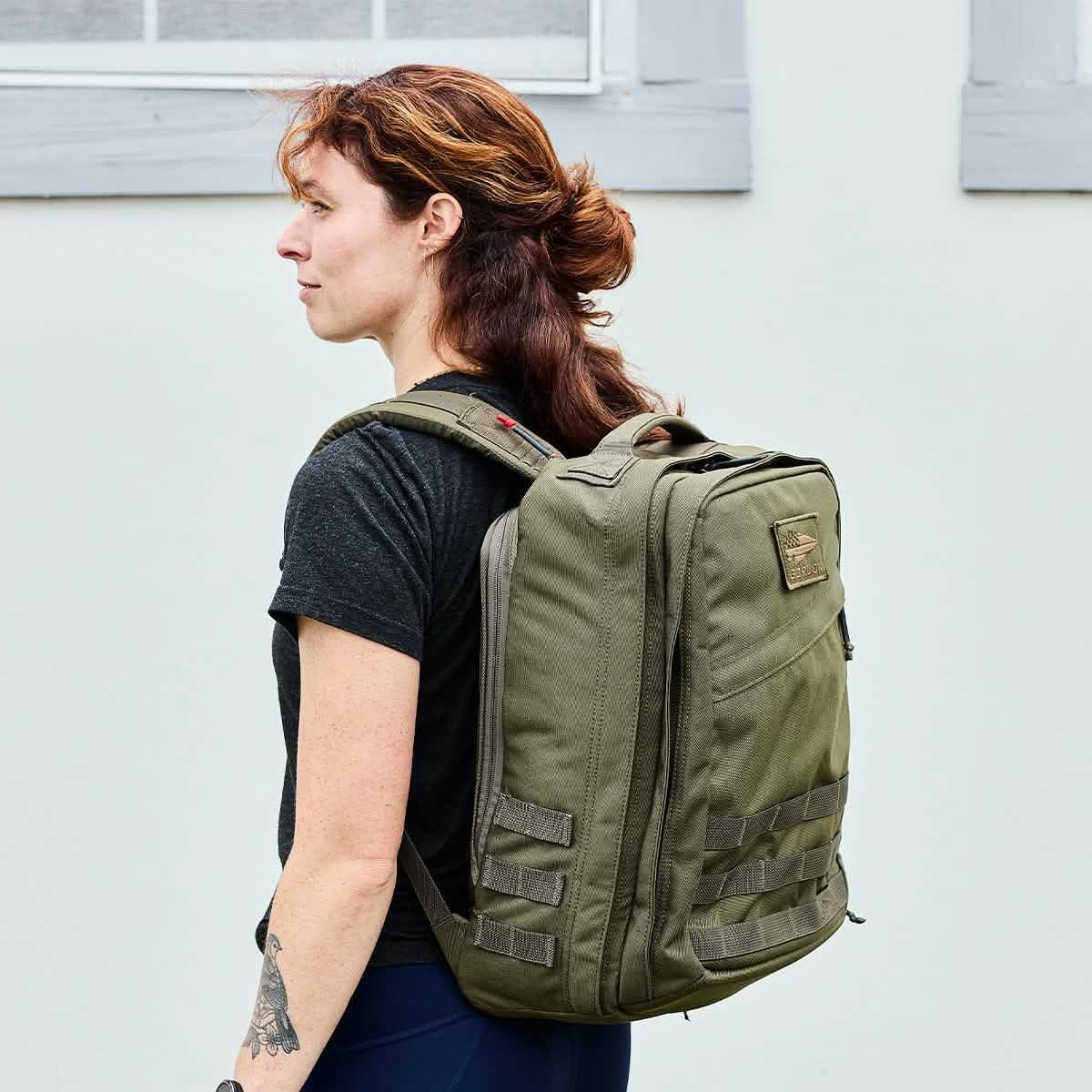 Woman wearing GORUCK Ranger Green rucksack backpack outdoors, durable rucking gear