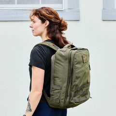 Woman wearing GORUCK Ranger Green rucksack backpack outdoors, durable rucking gear