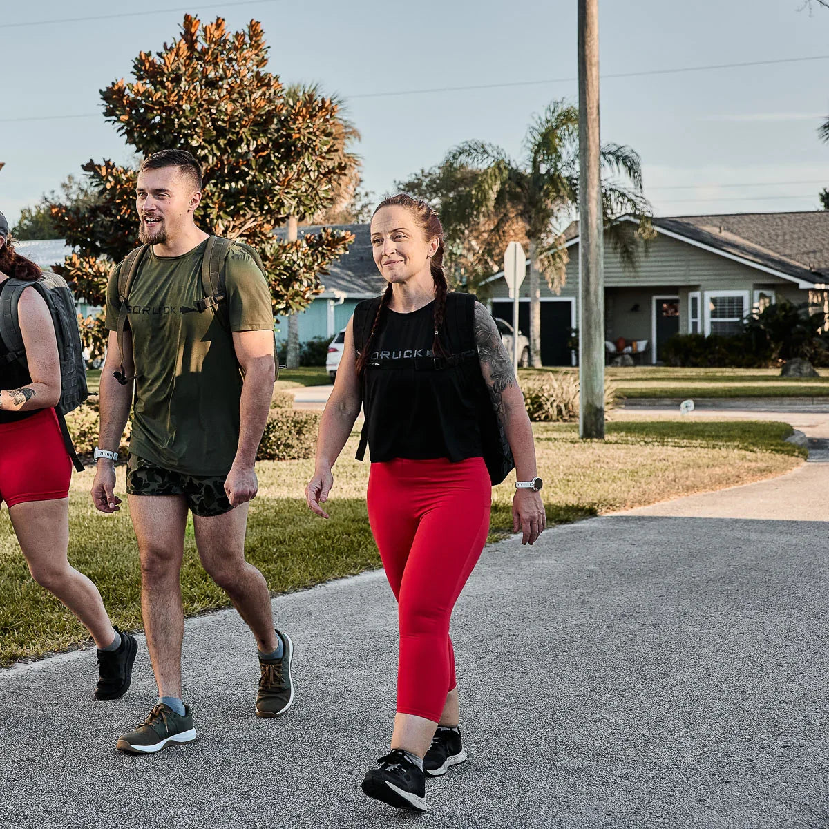 Group of people rucking in GORUCK gear and red cropped leggings outdoors