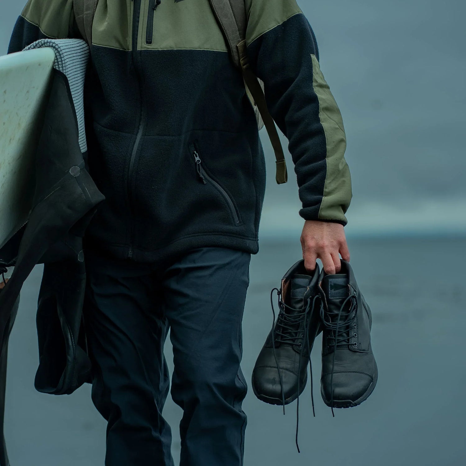 GORUCK rucking gear closeup, person holding boots and wetsuit by the beach