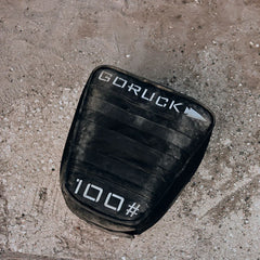 GORUCK 100-pound sand training weight on rough outdoor ground, durable rucking gear