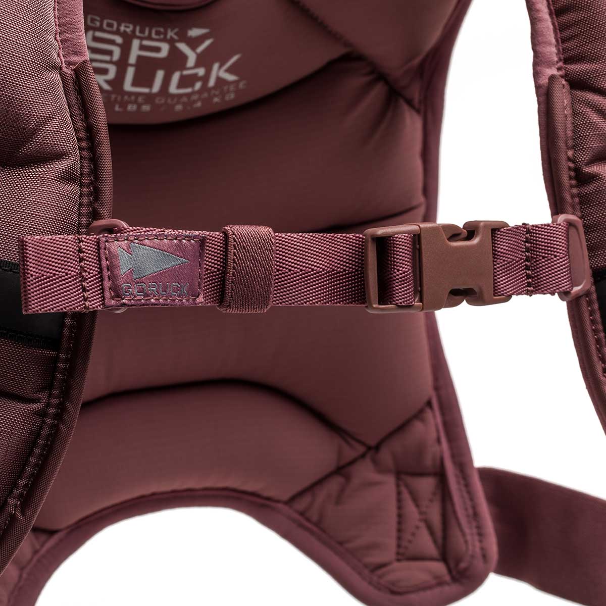 Close-up of a maroon Spy Ruck | Women's Weighted Vest strap and buckle, featuring the logo and padded detail—ideal for pairing with your training gear.