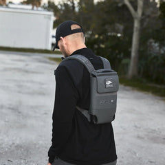 Man outdoors wearing black cap and GORUCK rucking backpack on gravel path