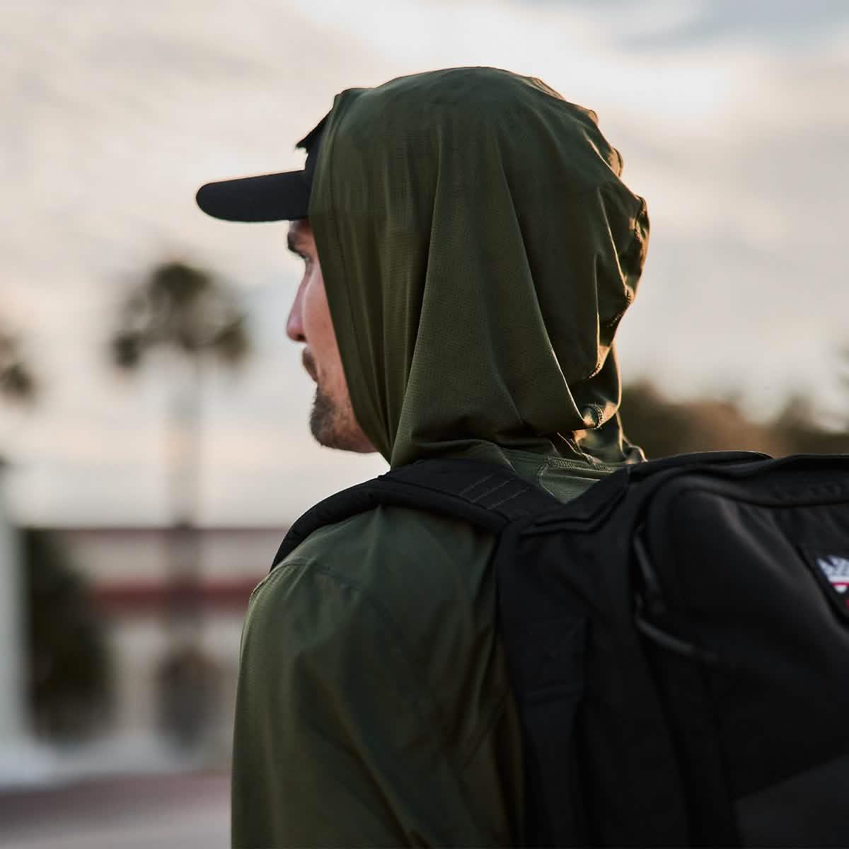 Man in green GORUCK Tough Mesh Hoodie with black backpack outdoors, rucking gear focus