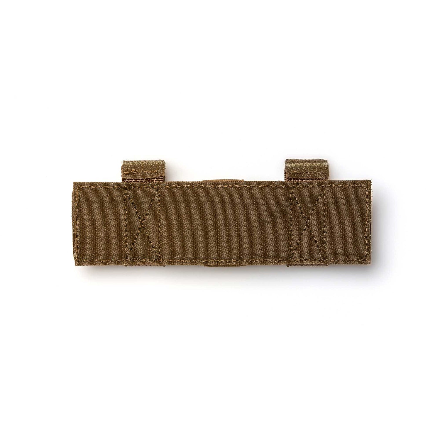 The Tourniquet Attachment is a brown tactical fabric strap with two loops and reinforced stitching for secure tourniquet storage, shown laid flat on a white background.