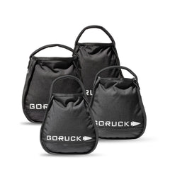 Four black GORUCK Kettlebell Bundle sandbags of different sizes with handles, grouped on a white background—each built tough like portable sand kettlebells and backed by a lifetime guarantee.