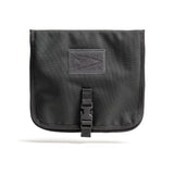 The Wire Dopp is a black rectangular EDC essentials pouch with a buckle closure and front patch, ideal as a rugged tech accessory bag, shown here against a white background.