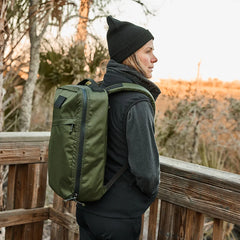 Woman wearing GORUCK Tough Dry fleece vest and olive green backpack outdoors