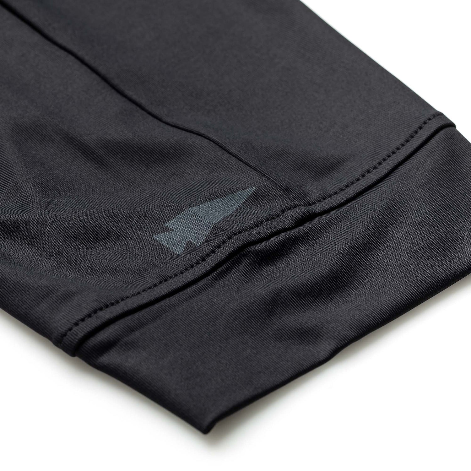 Close-up of the Women’s Training Performance Joggers shows black performance fabric, visible stitching, and a subtle arrow-shaped logo near the cuff.