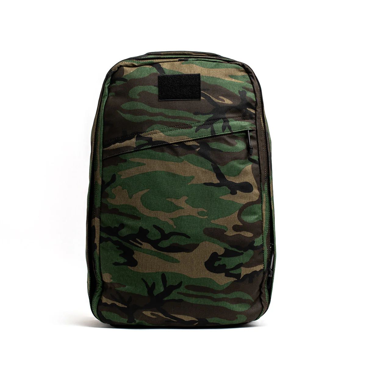 The GR1 USA - Heritage Woodland Camo M81 pack features a rectangular design with a green and brown M81 pattern on white, enhanced by full-grain leather handles for durability and style.
