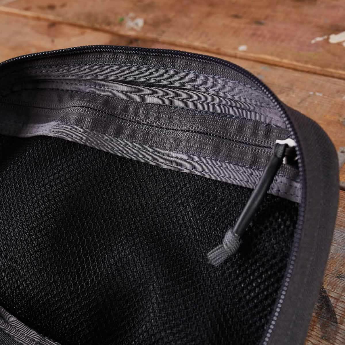 Close-up of GORUCK rucking gear mesh pocket with zipper on wood surface