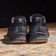 GORUCK black rucking shoes with rugged soles on a wooden surface, rear view