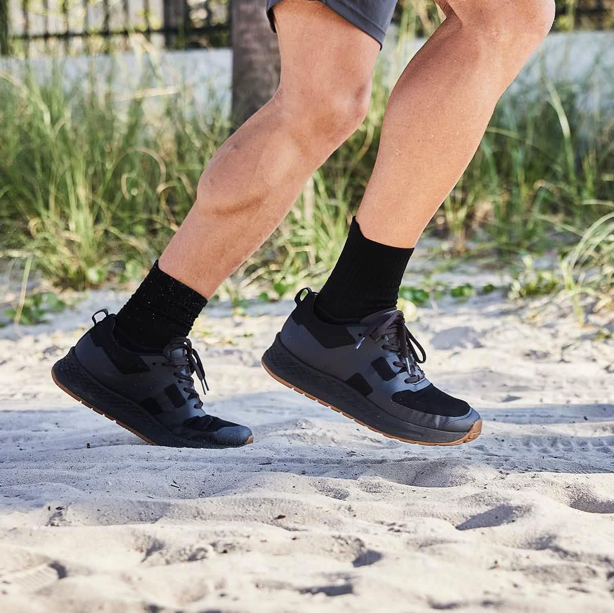 GORUCK black rucking shoes on person running in sand, outdoor fitness gear