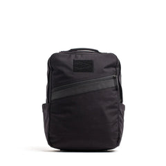 The KR1 2.0 - Kid Ruck is a black kids backpack with a diagonal front zipper, top handle, side pockets, and a simple rectangular shape—an indestructible school bag made for daily adventures. Add patches to make it yours!.