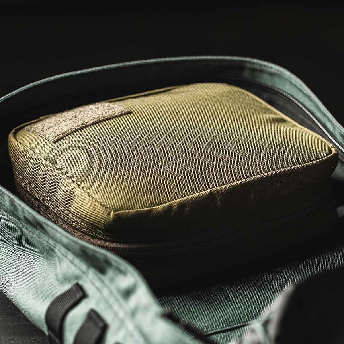 GORUCK field pocket in coyote brown inside a rucksack, rugged rucking gear close-up