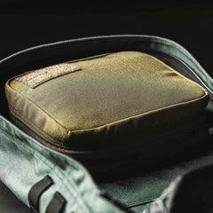 GORUCK field pocket in coyote brown inside a rucksack, rugged rucking gear close-up