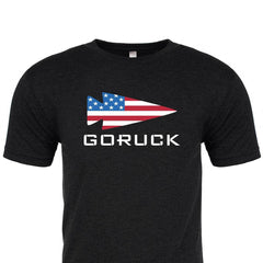 The T-shirt - GORUCK USA features a USA flag spearhead and "GORUCK" in bold, crafted from premium tri-blend fabric for comfort and durability.