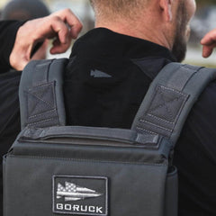 GORUCK grey rucksack with logo patch, worn outdoors by man in black jacket