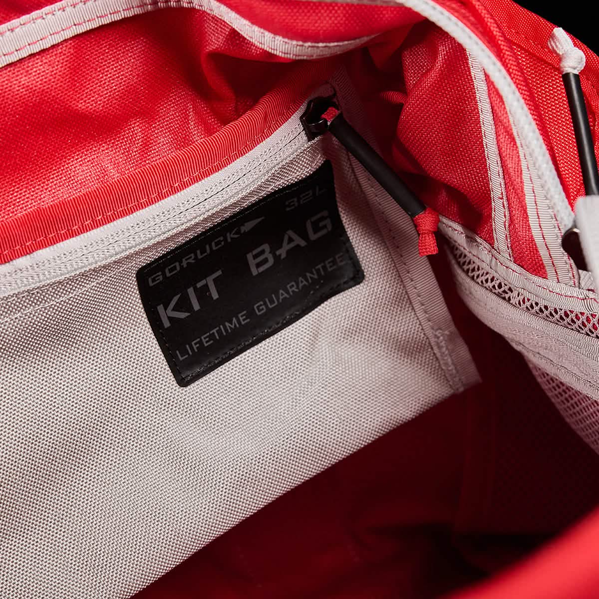 Close-up of the interior of a red and white GORUCK Kit Bag, showcasing a label that reads 