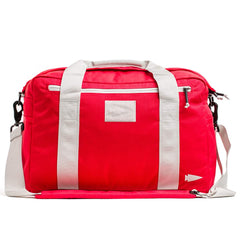 Introducing the GORUCK Kit Bag, a vibrant red duffel with contrasting white handles and an included shoulder strap, designed to resemble a Special Forces Flight Bag. Adorned with a minimal geometric logo and equipped with a convenient front zippered pocket, this bag combines style and utility for adventurous journeys.