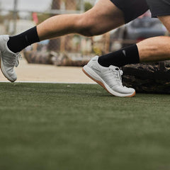 GORUCK white rucking shoes on athlete sprinting outdoors on artificial turf