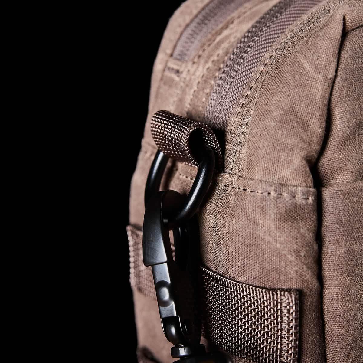 Close-up of GORUCK brown ruck sack with durable fabric and black carabiner clip