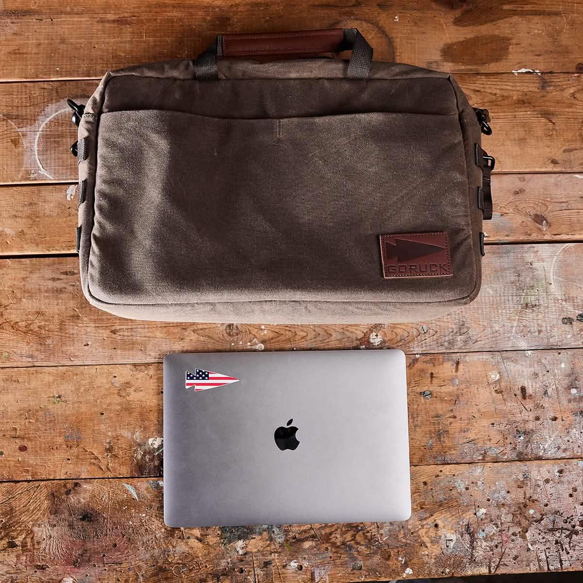 GORUCK brown rucking laptop bag and MacBook on rustic wooden table