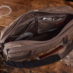 GORUCK brown tactical rucking laptop bag open on rustic wood table, showing organized compartments