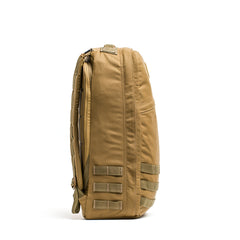 Side view of the tan GR1 rucksack featuring multiple straps and a zippered main compartment, inspired by Special Forces backpack design.