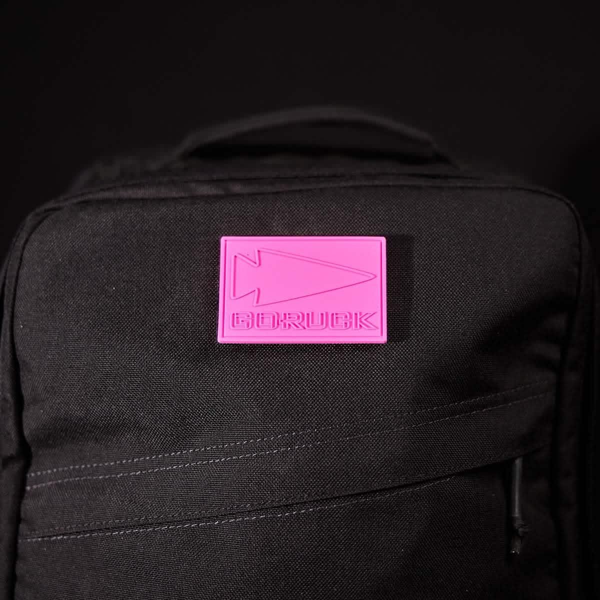 GORUCK black backpack with pink logo patch on front, tough rucking gear
