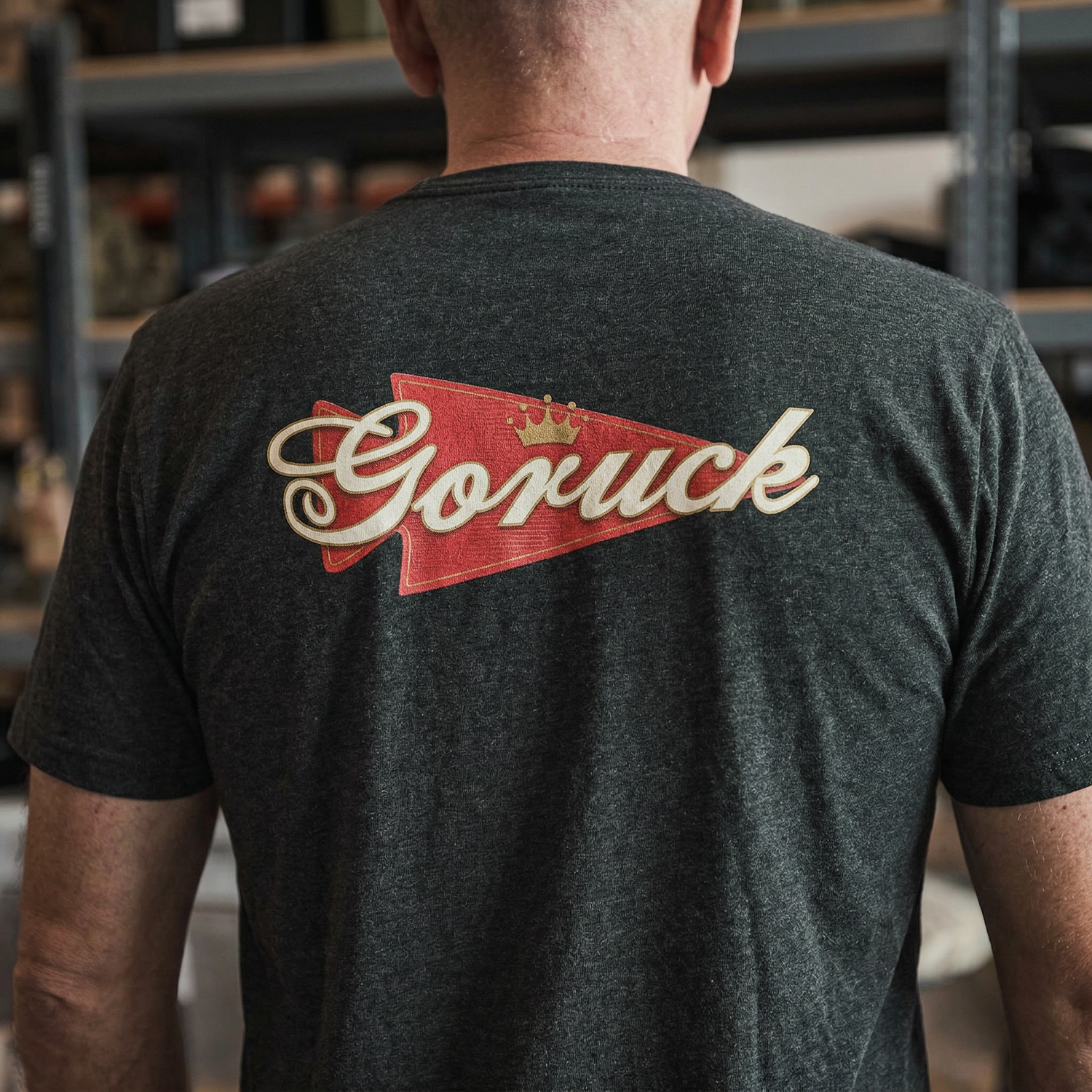Man wearing the GORUCK Bud Tee - Tri-BlendX, featuring a bold red and gold 