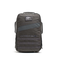 The Rucker 5.0, a black GORUCK rucksack with a front patch and multiple handles, designed for rucking, stands upright on a white background.