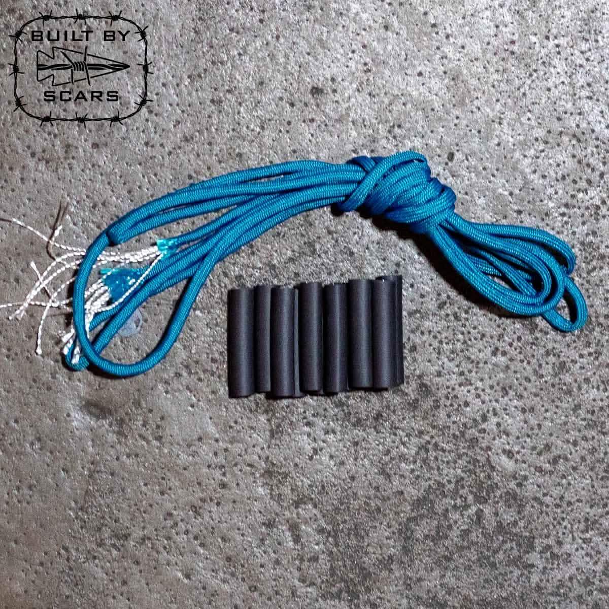 GORUCK teal paracord and black sleeves kit on textured concrete, rucking gear accessories