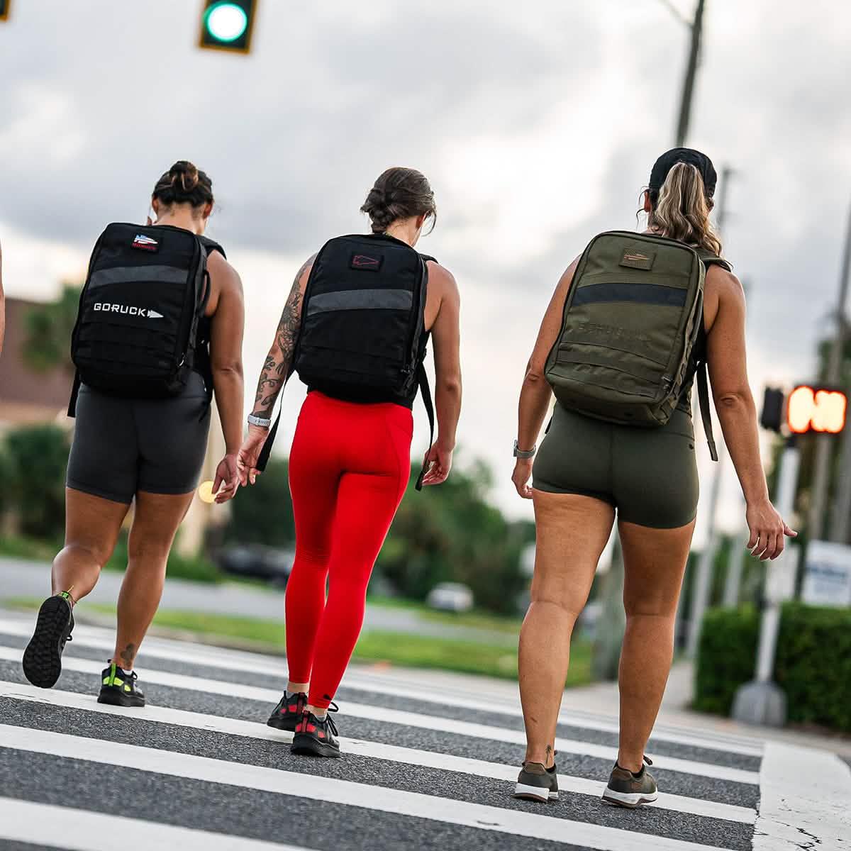 Three women rucking with GORUCK backpacks crosswalk outdoors fitness lifestyle