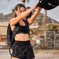 Woman rucking outdoors in GORUCK black camo shorts and rucksack, active fitness gear
