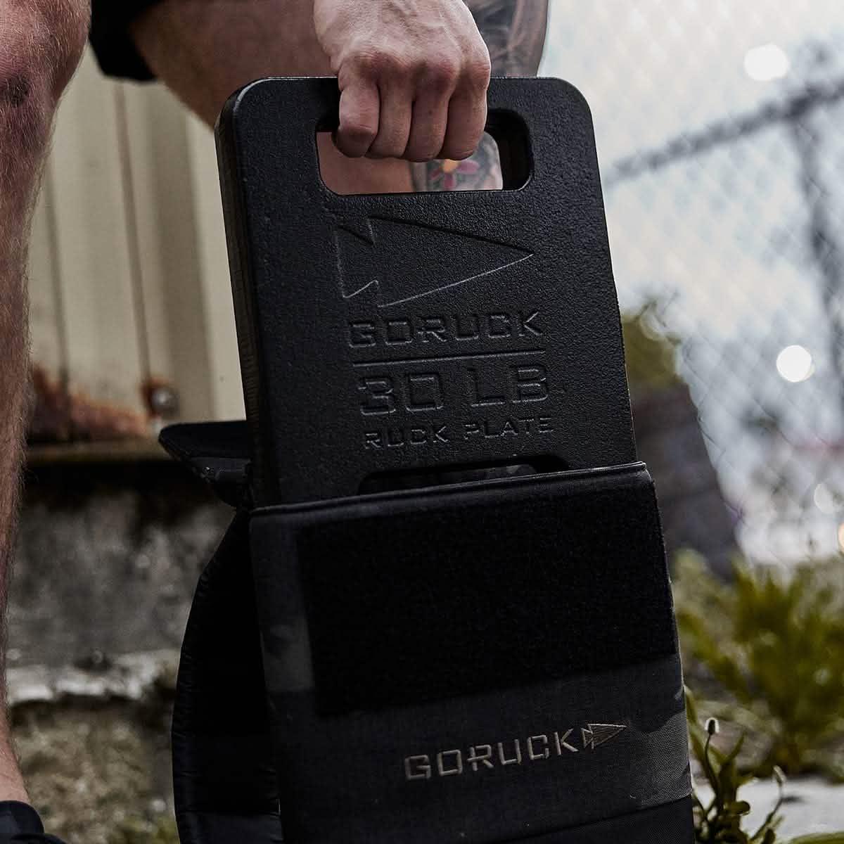 GORUCK 30 lb ruck plate held by person, outdoors, durable rucking gear close-up