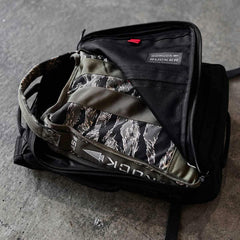 GORUCK Rucker backpack with camo ruck plate in open compartment on concrete floor