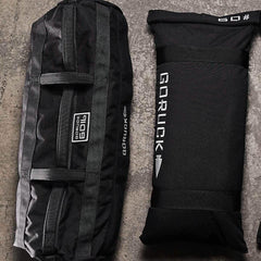 GORUCK 60lb sandbag and filler bag on concrete surface, rucking gear for training