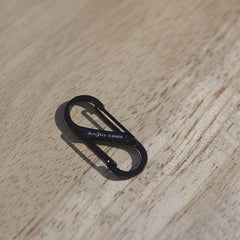 Black Nite Ize S-Biner carabiner on wood surface, GORUCK rucking gear accessory