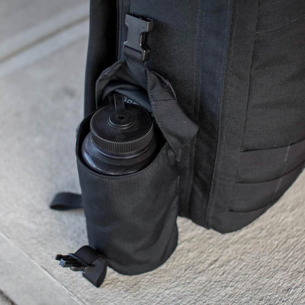 GORUCK backpack with full-panel water bottle pocket holding a Nalgene on concrete