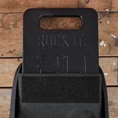 GORUCK 20lb ruck weight plate in black backpack on wooden background