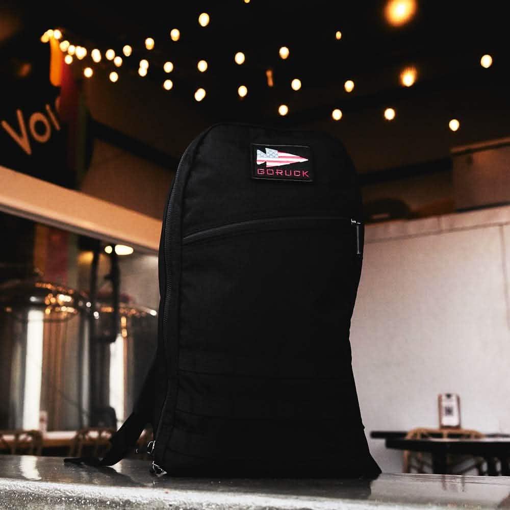 GORUCK black rucksack on counter in brewery with string lights overhead