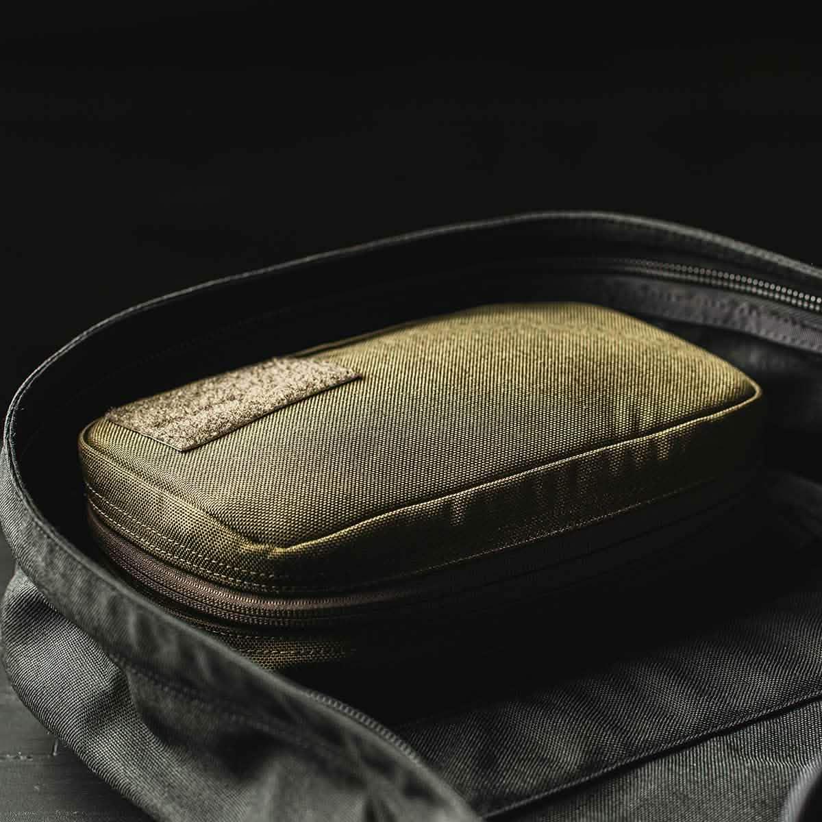 GORUCK olive field pocket pouch in a black backpack, rugged rucking gear for organization