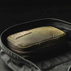 GORUCK olive field pocket pouch in a black backpack, rugged rucking gear for organization