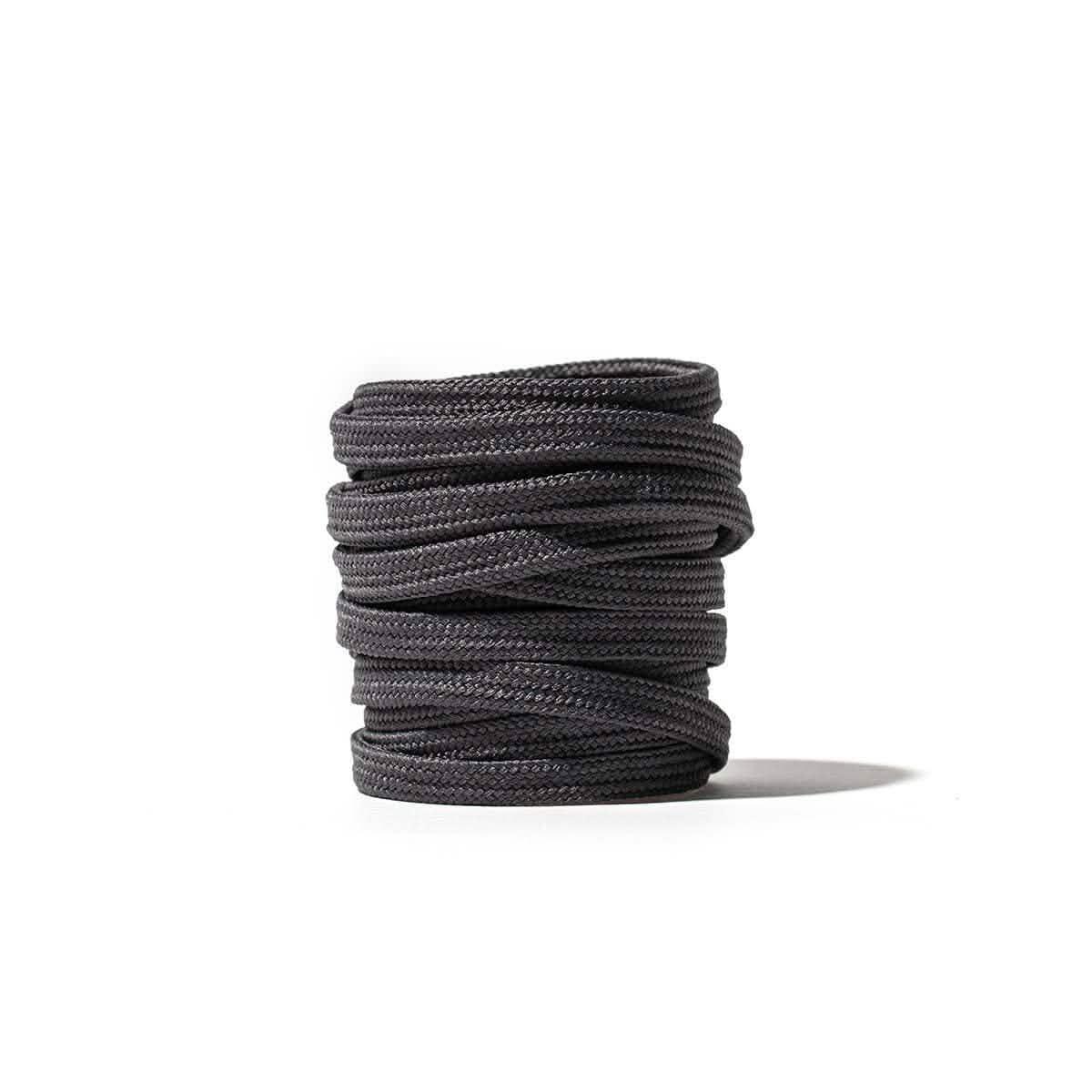 Coiled grey GORUCK boot laces on white background, durable rucking footwear accessory